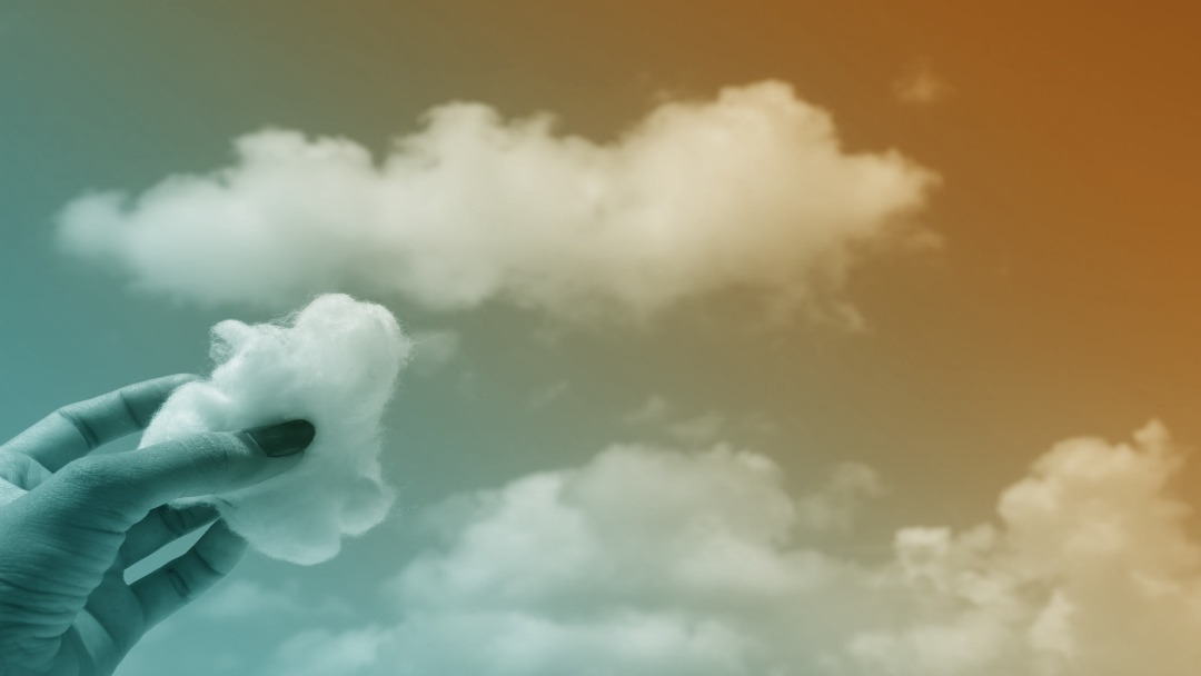 Nuage dans le ciel et mains tenant un morceau de coton en forme de nuage