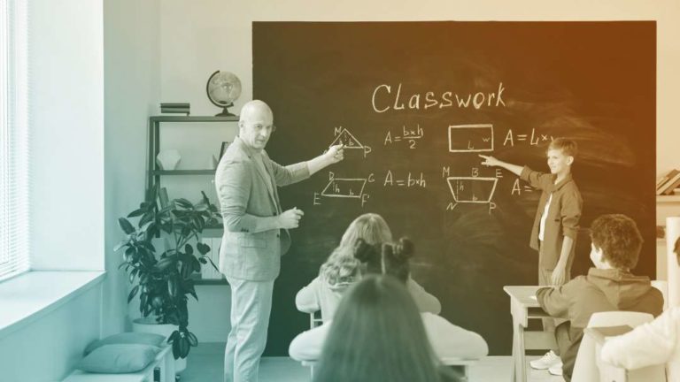 Professeur et élève qui pointent du doigt des figures géométriques au tableau