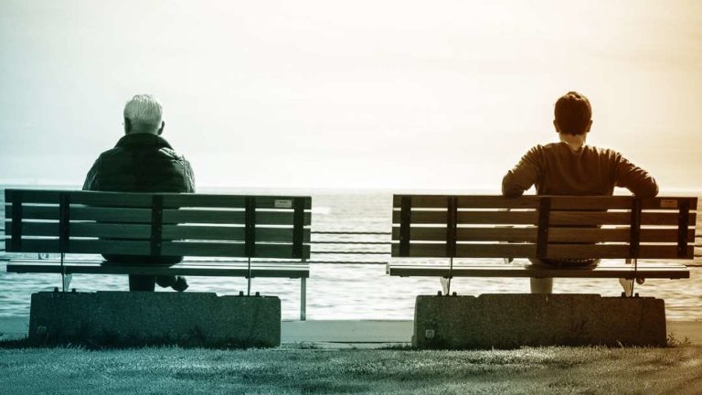 Un homme d'âge mûr et un jeune homme assis sur deux bancs séparés