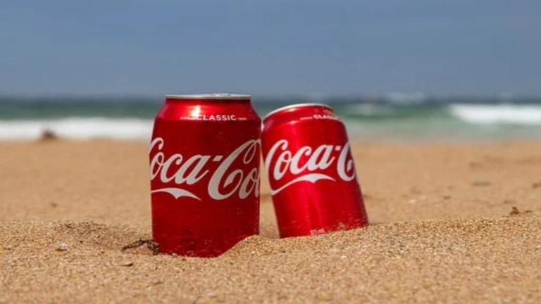 2 canettes de Coca Cola sur une plage